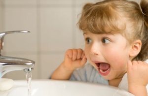 Ребенок чистит зубы нитью